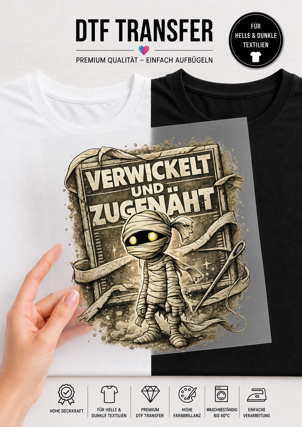 Ein transparentes DTF-Transfer-Bügelbild, gehalten von einer Hand vor einem geteilten T-Shirt-Hintergrund (links weiß, rechts schwarz). Das Motiv zeigt eine kleine Comic-Mumie mit Bandagen und leuchtend gelben Augen. Um die Mumie herum schweben eine Nähnadel und ein Faden. Im Hintergrund ist eine alte, rissige Steintafel mit dem deutschen Schriftzug „VERWICKELT UND ZUGENÄHT“ im Vintage-Stil zu sehen. Am oberen und unteren Rand sind Produktinfos auf Deutsch platziert.